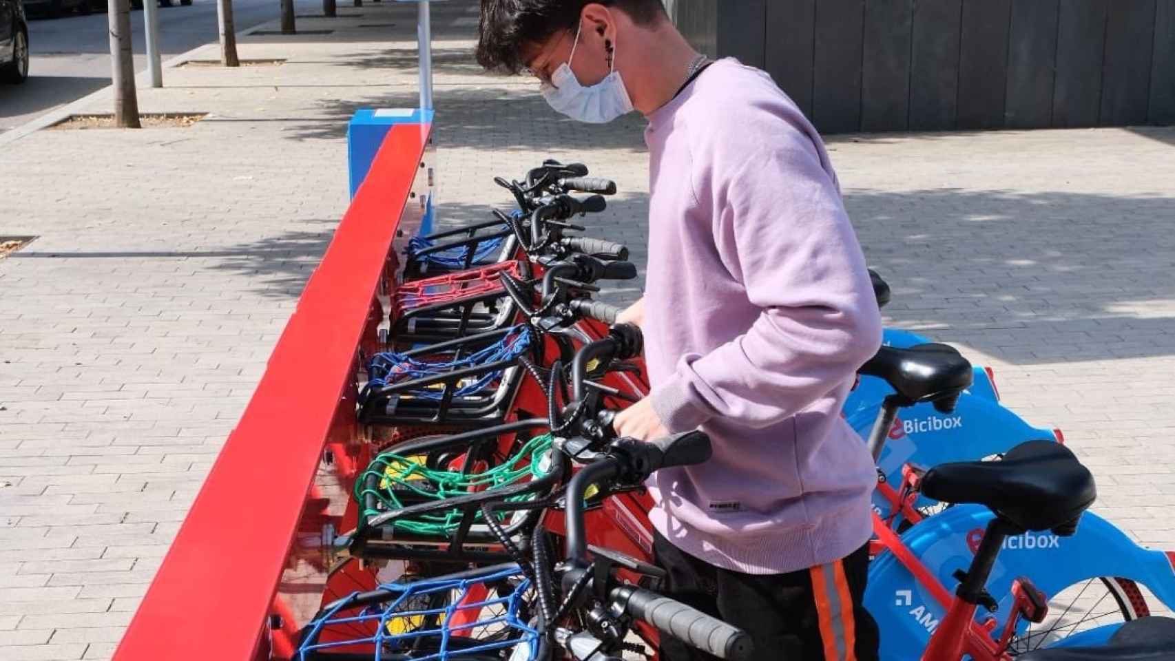 Un chico coge una bici del servicio e-Bicibox metropolitanas / AMB