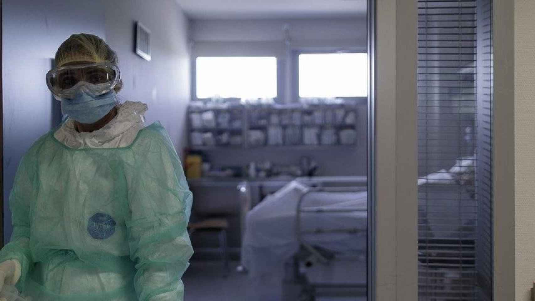 Un sanitario en la puerta de una habitación de la UCI en Barcelona / EUROPA PRESS