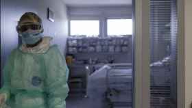 Un sanitario en la puerta de una habitación de la UCI en Barcelona / EUROPA PRESS