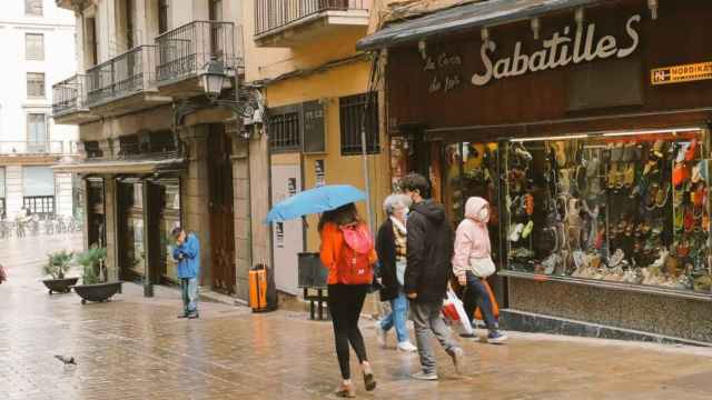 Un grupo de ciudadanos caminan por delante de un comercio barcelonés en el Gòtic / BARNA CENTRE