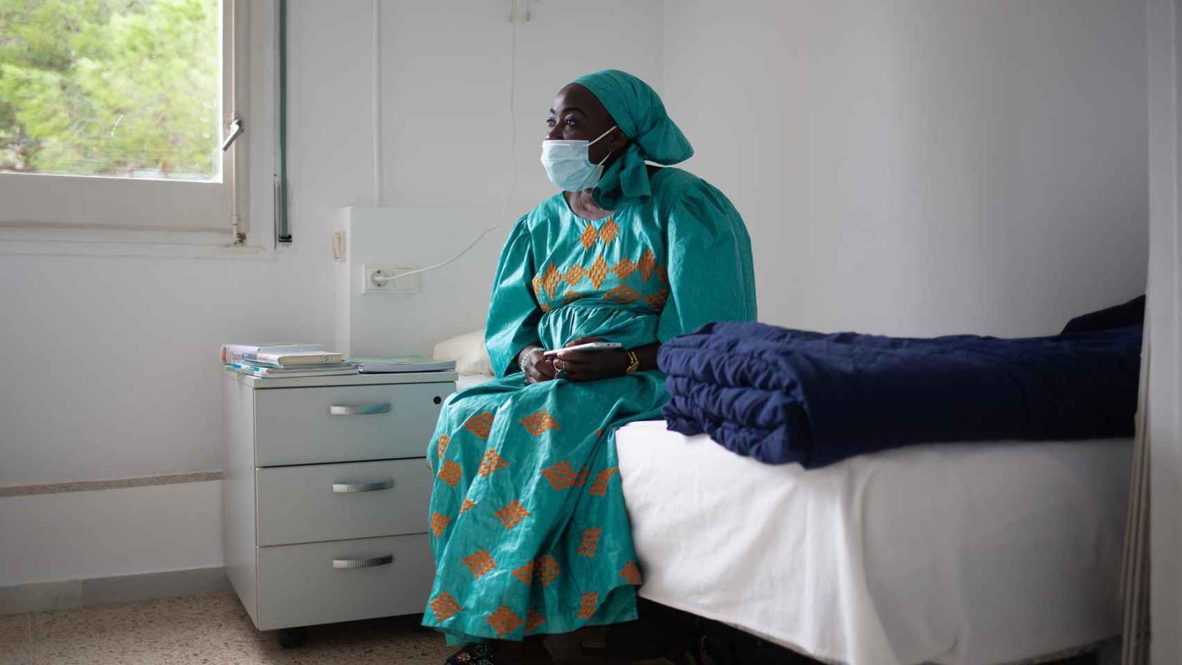 Sina Ndiaye, una mujer senegalesa que lleva 12 años residiendo en España, mira hacia la ventana al equipamiento para mujeres sin hogar, en Horta-Guinardó / EP-DAVID ZORRAKINO