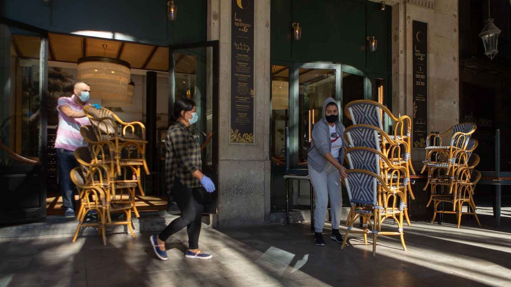 Trabajadores de una terraza del centro de Barcelona recogen por el aumento de casos de coronavirus / EFE - ENRIC FONTCUBERTA