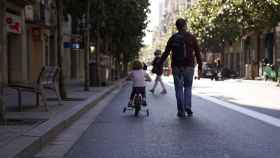 Un hombre pasea con una niña en la calle Gran de Gràcia / AYUNTAMIENTO DE BARCELONA