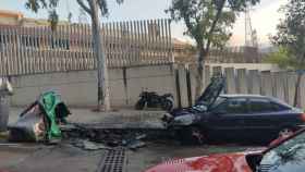 Un contenedor y un coche quemado en la calle de Nou Barris, delante de la escuela Pla de Fornells / FACEBOOK