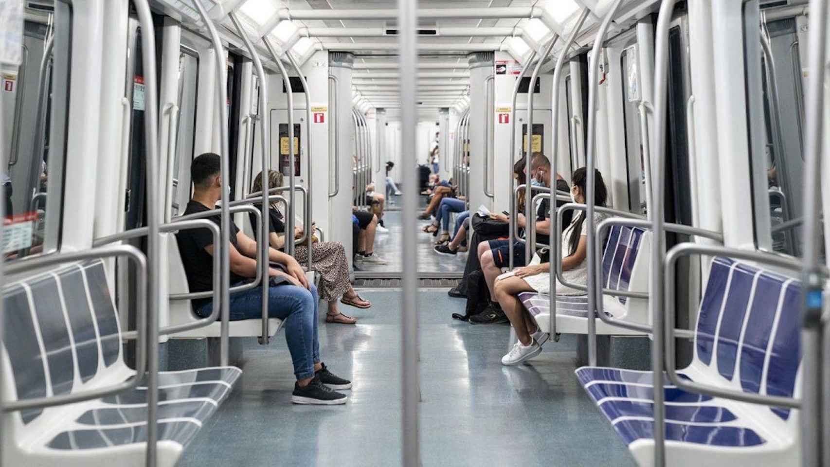 Varias personas sentadas en el metro de Barcelona y protegidas con mascarillas / ARCHIVO