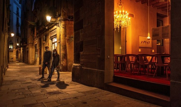 Una pareja ataviada con mascarillas pasa por delante de un restaurante cerrado en el centro histórico de Barcelona / EFE- Enric Fontcuberta
