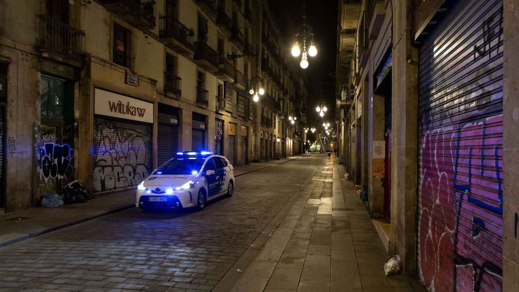 Un coche de la Guardia Urbana en la calle de Ferran, vacía, de Barcelona / EFE - ENRIC FONTCUBERTA