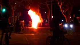 Contenedores en llamas en la plaza Urquinaona de Barcelona, alcanzando las luces de Navidad