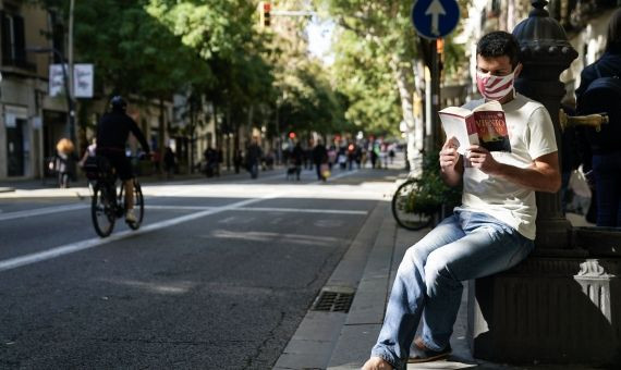 n hombre lee un libro en Sants en la conocida calle homónima cortada al tráfico / AYUNTAMIENTO