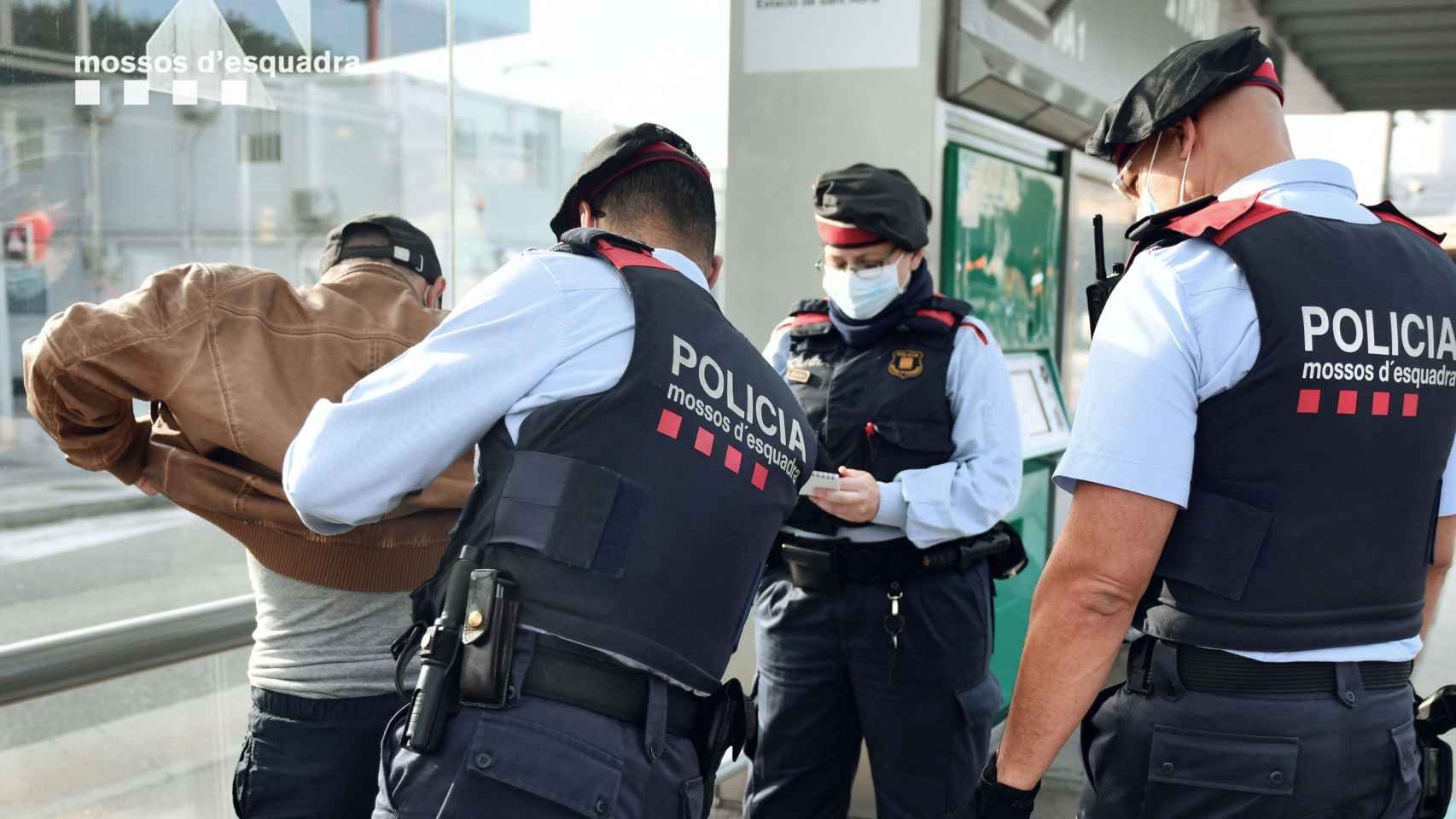 Tres agentes uniformados registran a una persona / MOSSOS D'ESQUADRA