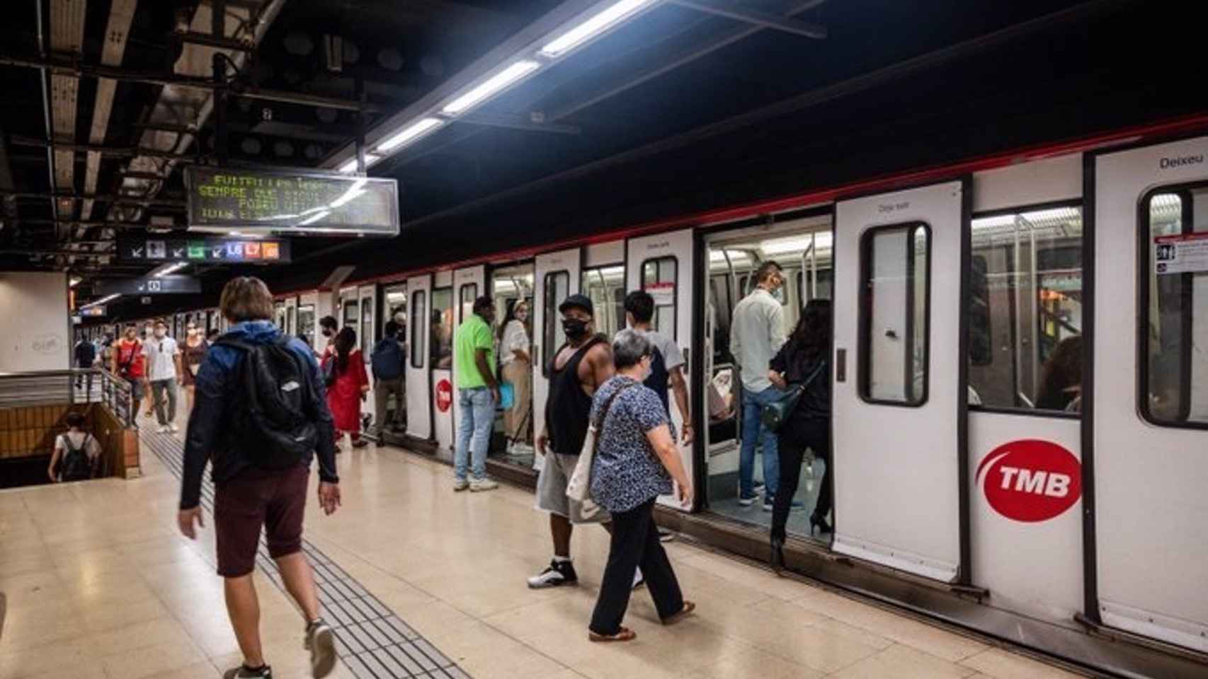 Usuarios del metro de Barcelona con un convoy estacionado / TMB