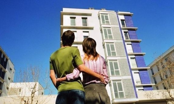 Una pareja joven frente a unas viviendas de nueva construcción