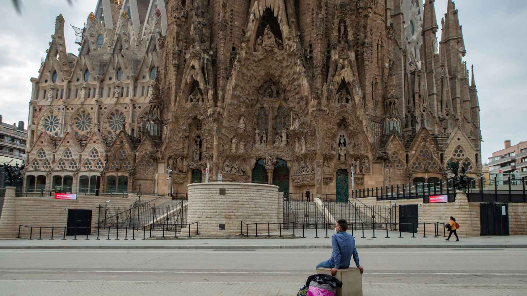 Un hombre sentado ante la Sagrada Familia / EFE - Enric Fontcuberta