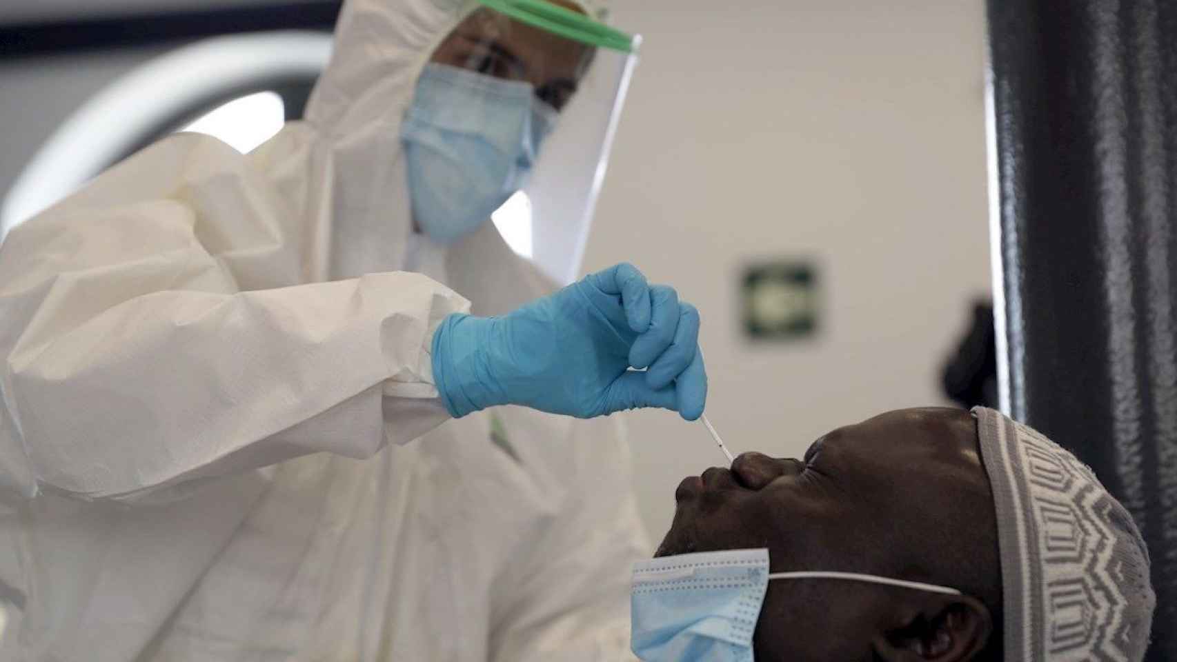 Un sanitario realizando una prueba PCR a un viajero de uno de los de países de riesgo por coronavirus / EFE