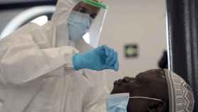 Un sanitario realizando una prueba PCR a un viajero de uno de los de países de riesgo por coronavirus / EFE