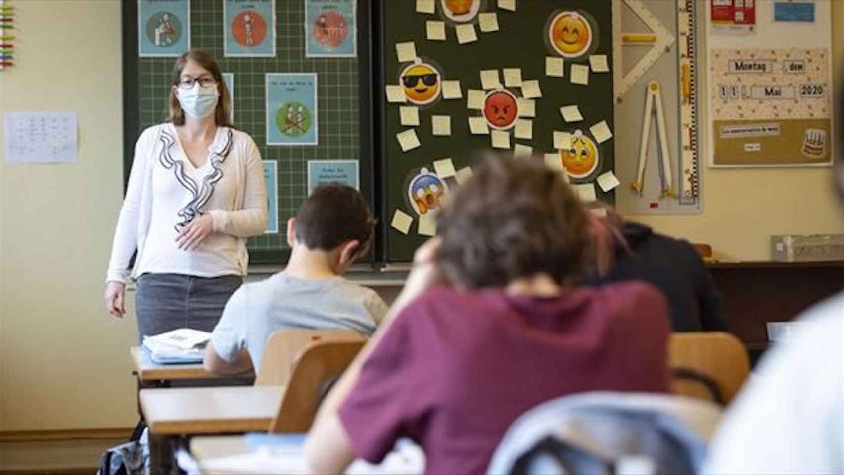 Una maestra y sus alumnos, en una clase de una escuela de Barcelona con la mascarilla / EFE