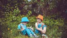 Dos niños leyendo libros en un bosque / Freepik