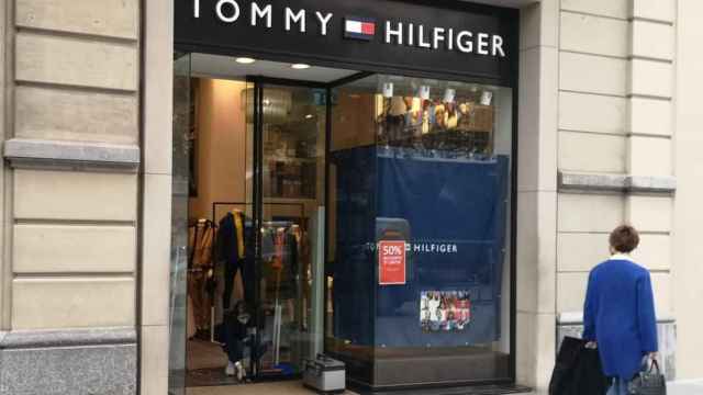 Una empleada de la tienda Tommy Hilfiger, uno de los dos comercios de lujo que han sido asaltados esta madrugada en el paseo de Gràcia, arreglando la puerta / G.A.