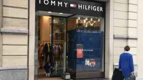 Una empleada de la tienda Tommy Hilfiger, uno de los dos comercios de lujo que han sido asaltados esta madrugada en el paseo de Gràcia, arreglando la puerta / G.A.