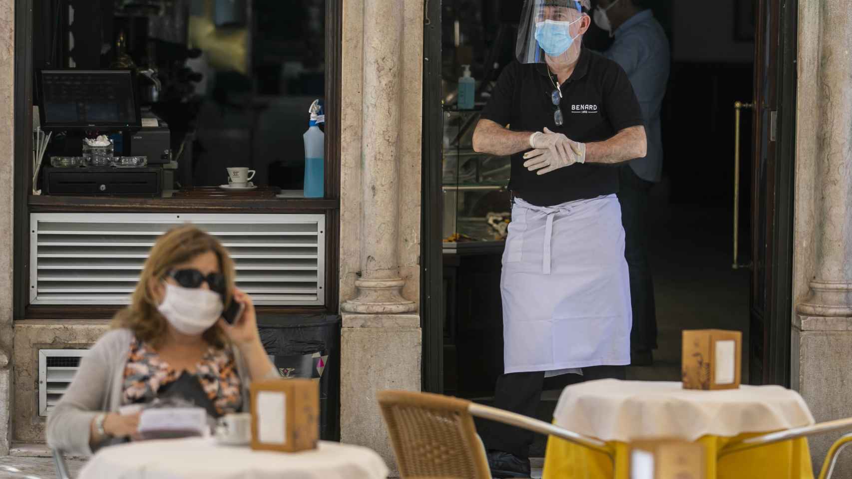 Una clienta y un camarero de un restaurante durante la reapertura de la restauración en Barcelona / EFE