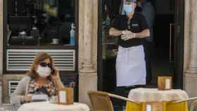 Una clienta y un camarero de un restaurante durante la reapertura de la restauración en Barcelona / EFE
