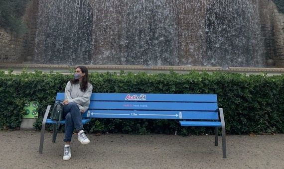 Una mujer sentada en uno de los extremos de uno de los bancos anticovid en el parque de Montjuïc / ACTIMEL