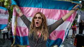 Una manifestante con la bandera trans en brazos / Oliver de Ros