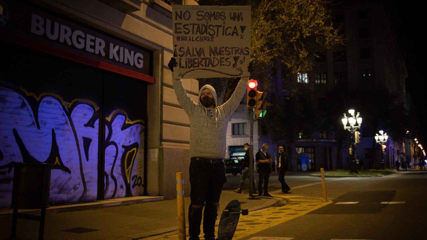 Una persona participa en una concentración de trabajadores del sector hostelero y el ocio nocturno en la plaza Urquinaona / EUROPA PRESS - David Zorrakino