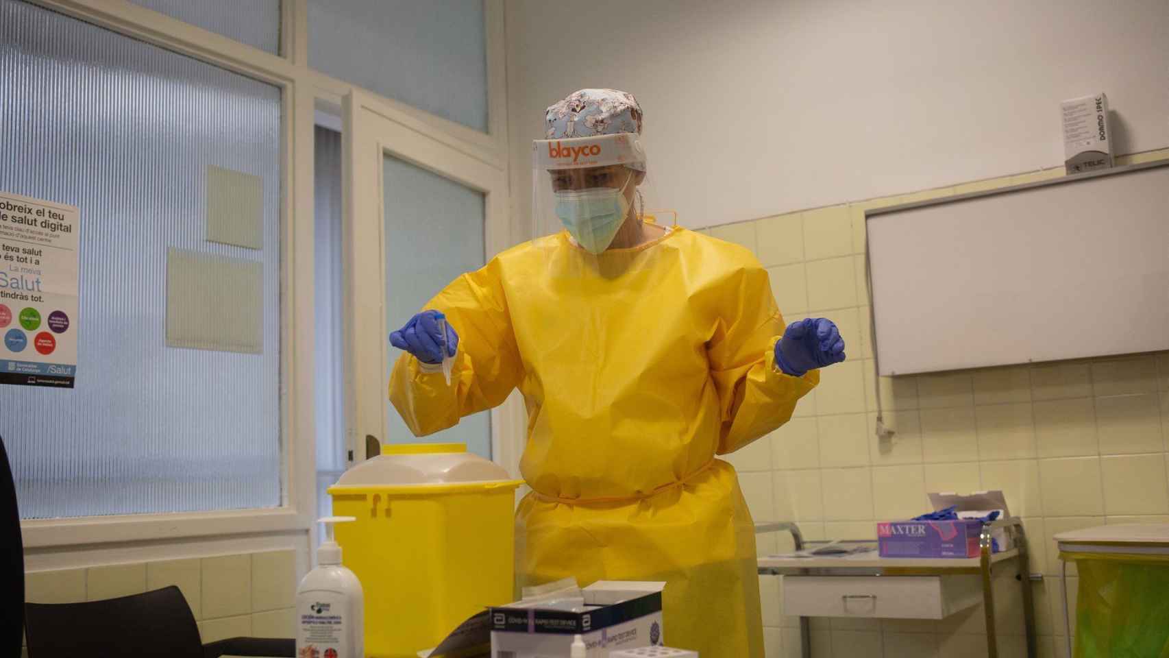 Una sanitaria introduce en una papelera habilitada restos de materiales utilizados para realizar test de antígenos en un CAP de Barcelona / EP - DAVID ZORRAKINO