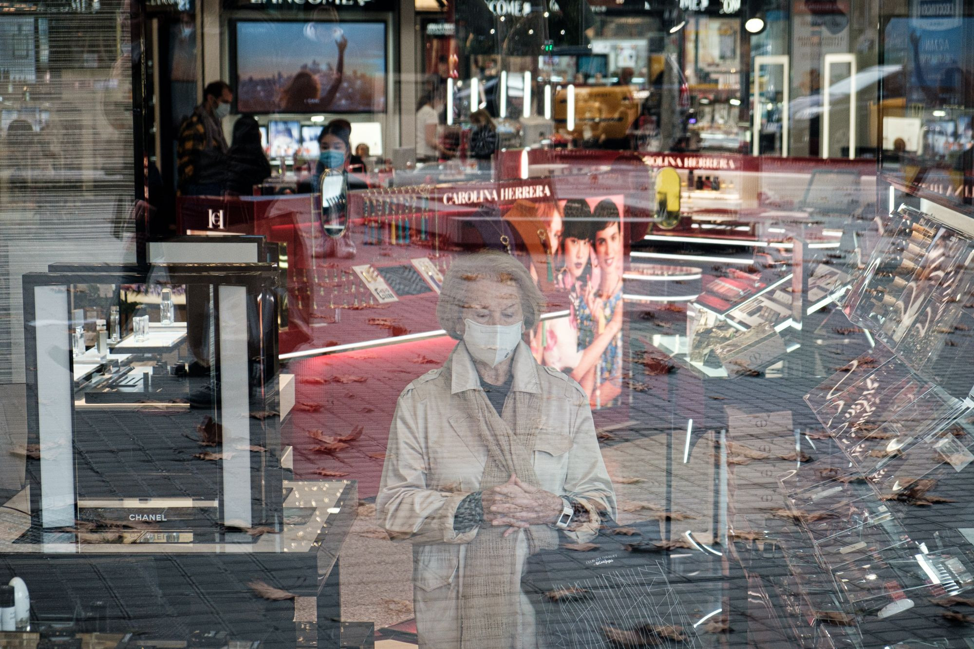 Una mujer, con la mirada perdida, observa a través de los cristales durante sus compras de Black Friday en Barcelona / PABLO MIRANZO