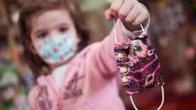 Una niña sujeta una mascarilla con la mano en una imagen de archivo / EUROPA PRESS