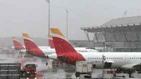Aeropuerto con aviones de Iberia cubiertos de nieve / EFE