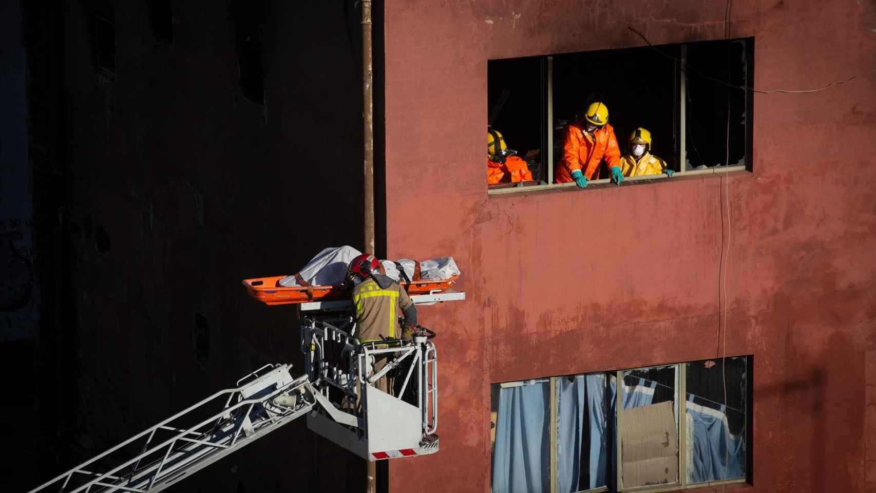 Los Bomberos de la Generalitat han retirado del interior de la nave dos de los tres cuerpos sin vida de las víctimas del incendio de Badalona (Barcelona)/ DAVID ZORRAKINO -