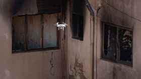 En la imagen un drone toma imágenes para valorar los daños causados en la nave a causa del incendio / EFE - Enric Fontcuberta
