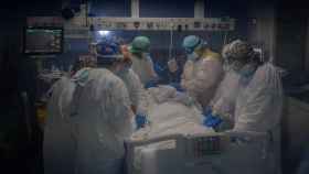 Trabajadores sanitarios protegidos atienden a un paciente en la Unidad de Cuidados Intensivos / EUROPA PRESS - David Zorrakino