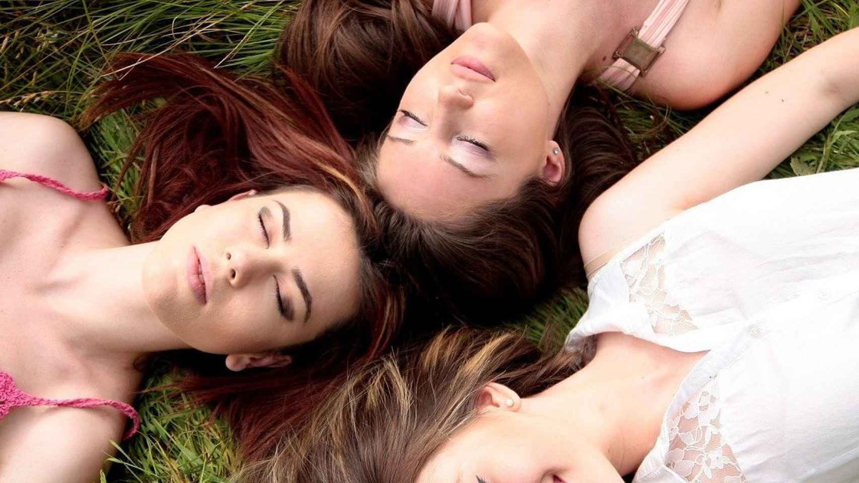 Chicas maquilladas tumbadas en la hierba