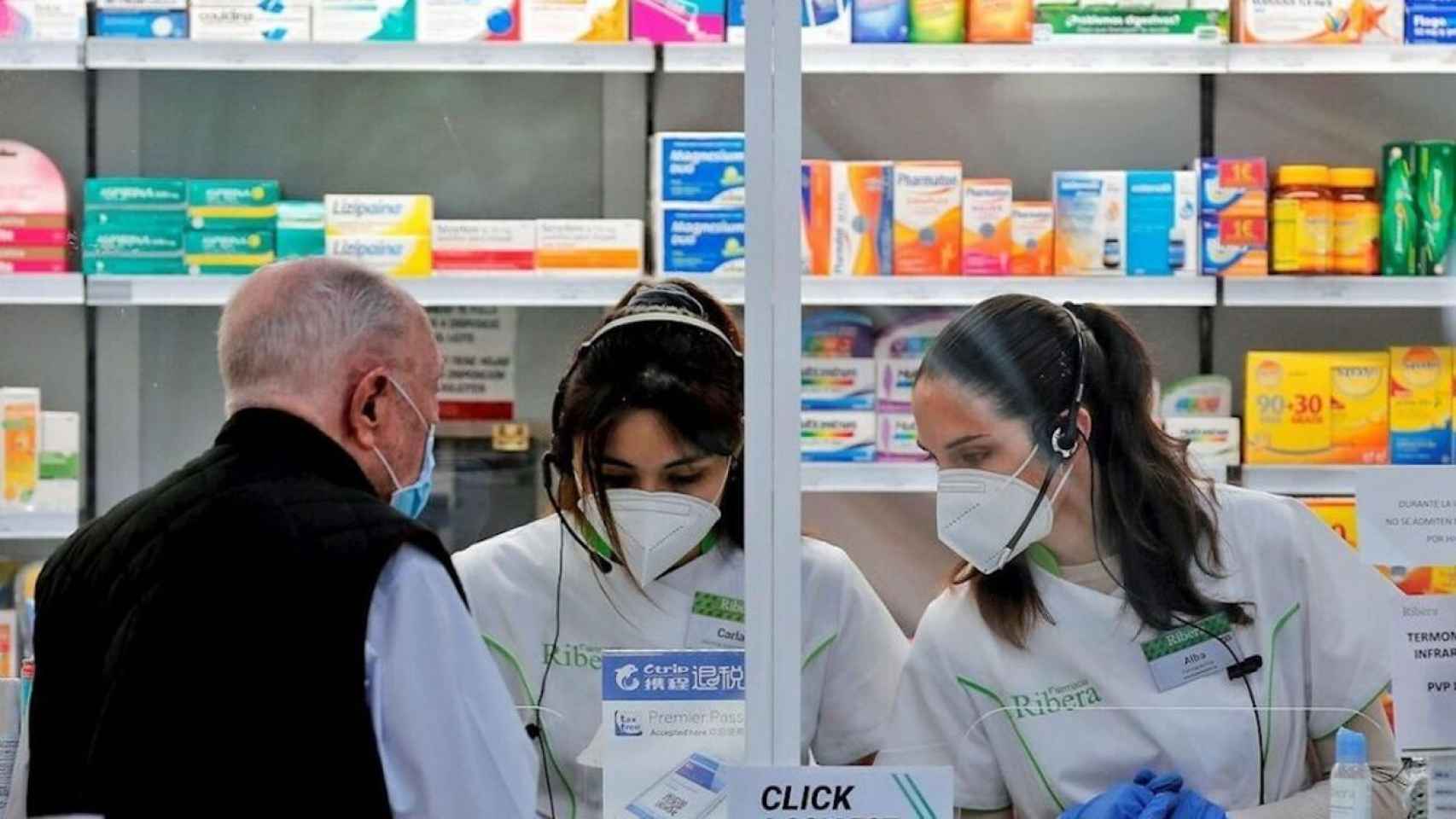 Dos trabajadoras atendiendo a un cliente en una farmacia / EFE