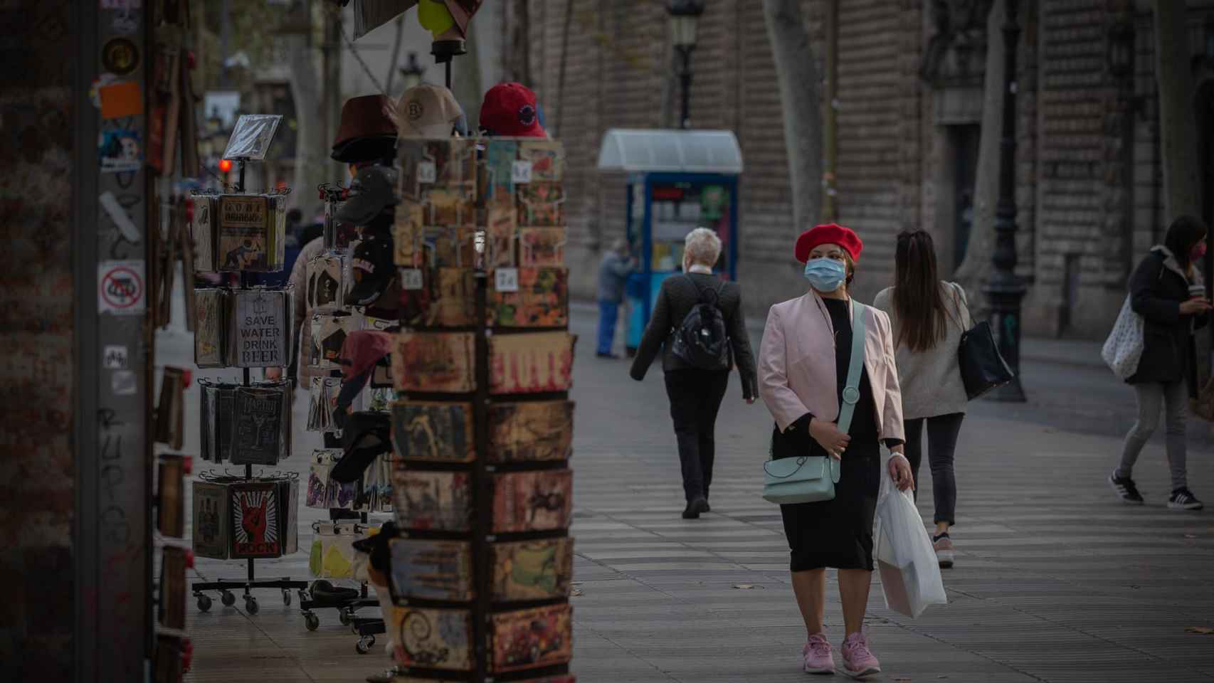 Una mujer frente a una tienda de artículos turísticos en Barcelona / EUROPA PRESS - David Zorrakino