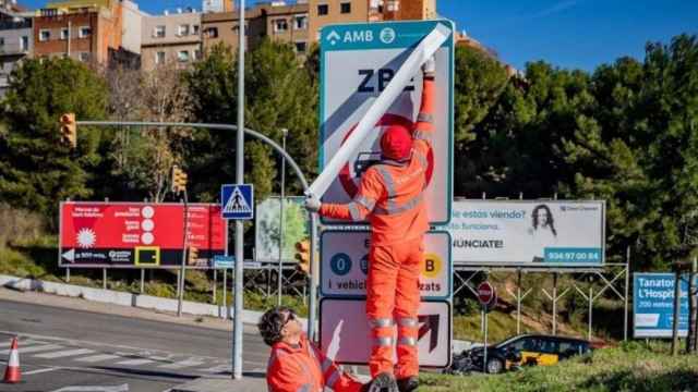 Operarios instalando las señales de tráfico de la Zona de Bajas Emisiones / AMB