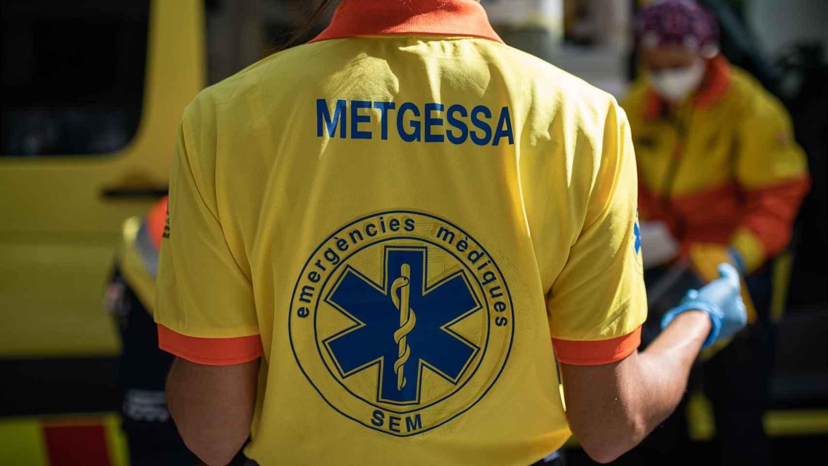 Dos técnicos del Sistema de Emergencias Médicas (SEM) de la Generalitat de Cataluña mueven una camilla junto a una ambulancia durante un servicio y limpieza de EPIs / EUROPA PRESS