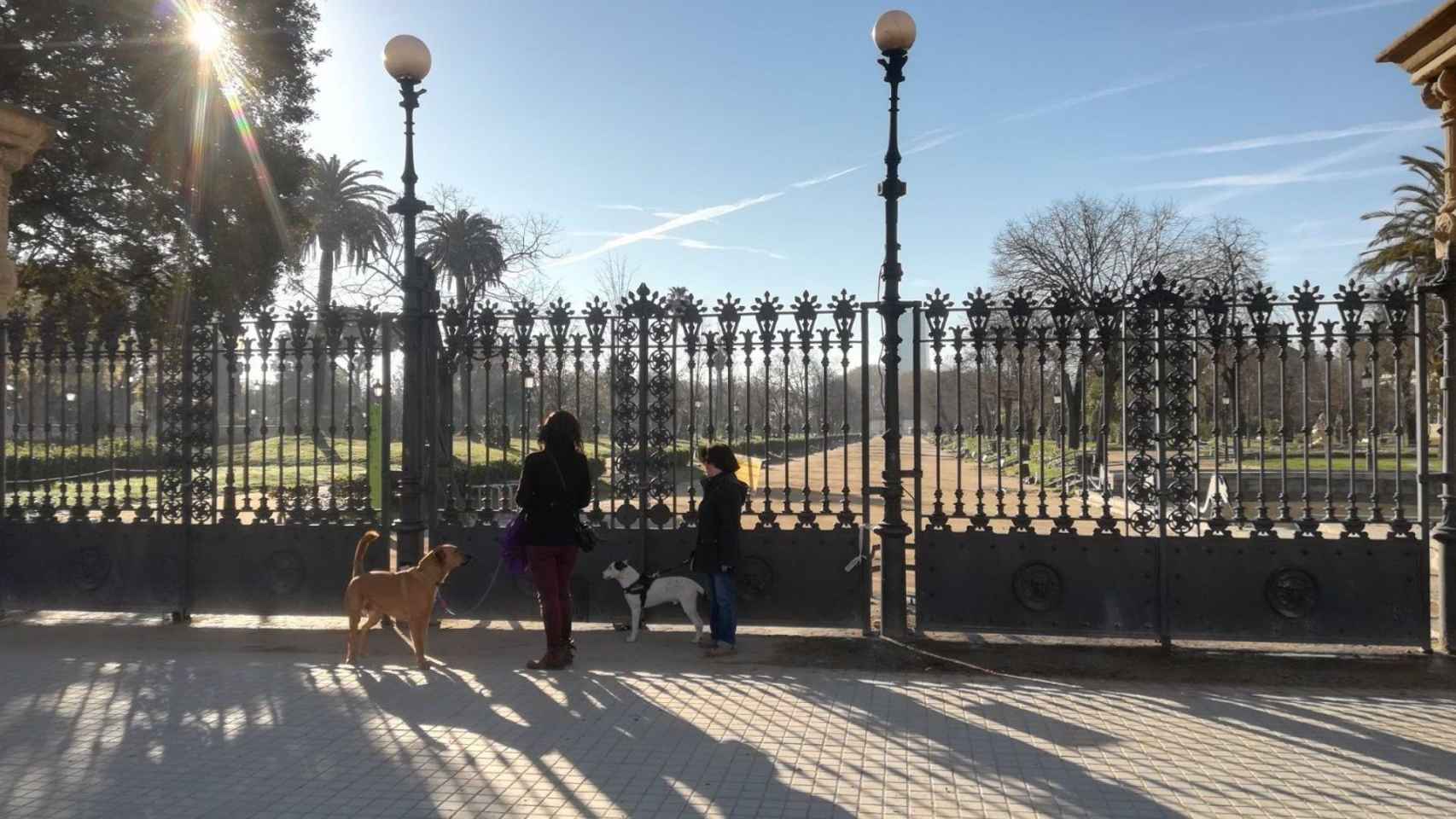 Dos mujeres pasean a sus perros por la entrada del Parc de la Ciutadella de Barcelona, cerrado (archivo) / EUROPA PRESS