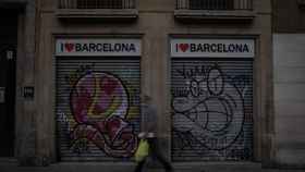 Un hombre pasea frente a un comercio cerrado de Barcelona / EUROPA PRESS