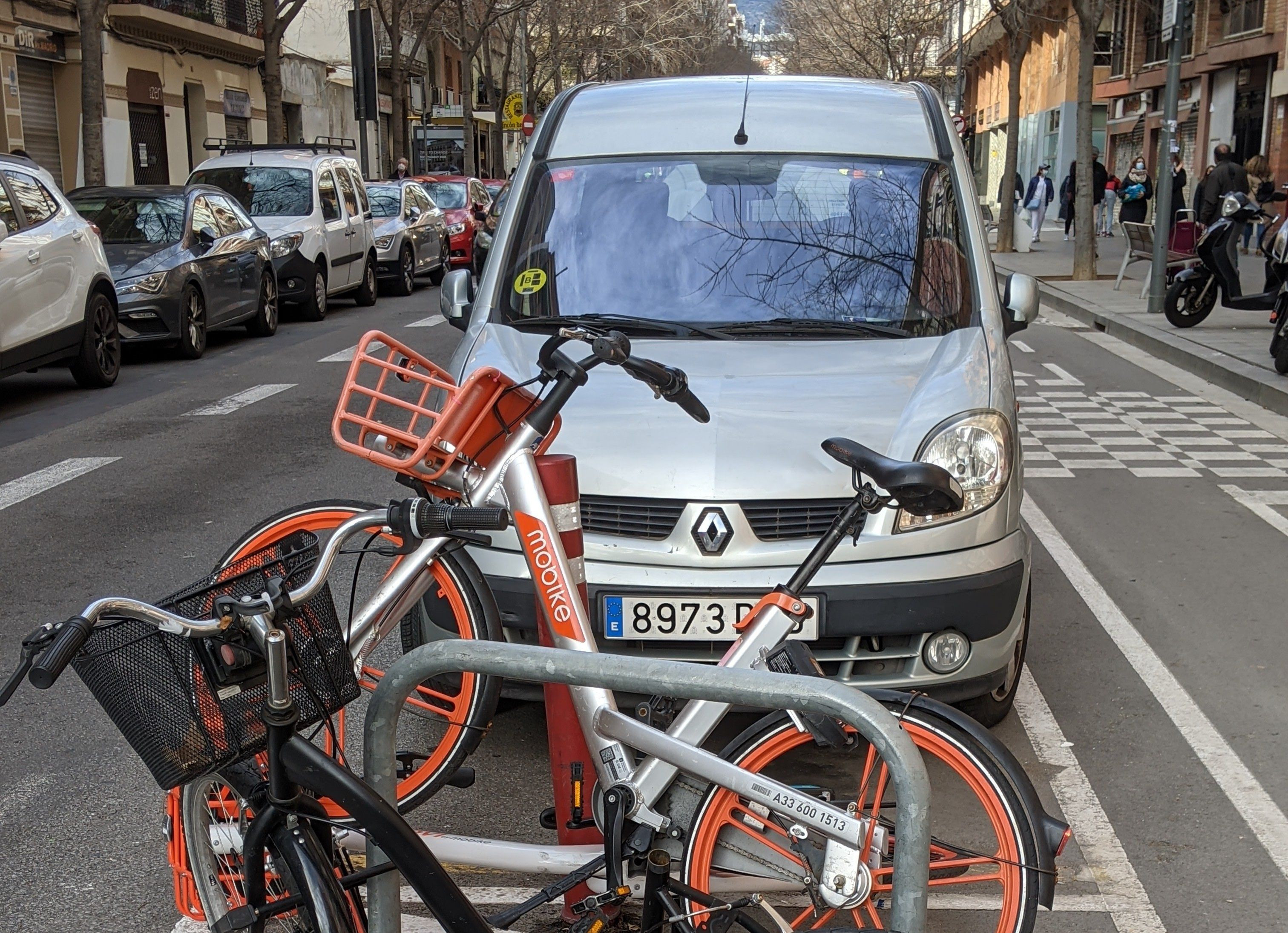 Dos bicicletas aparcadas enfrente de un coche en Barcelona / @BiciHater
