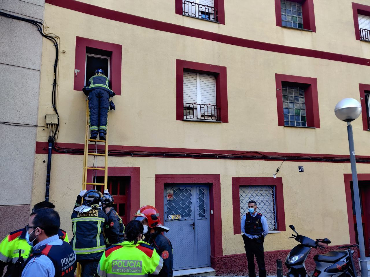 Un bombero asomándose a la ventana desde donde Pep amenazó con tirarse / TWITTER-Sindicat d’Habitatge de Nou Barris
