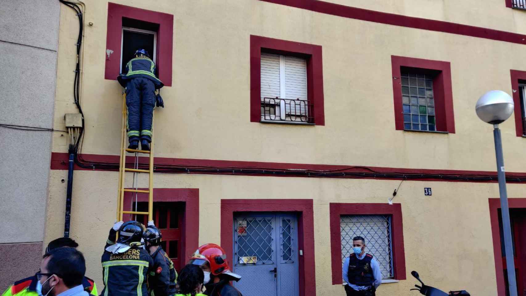 Un bombero asomándose a la ventana desde donde Pep amenazó con tirarse / TWITTER-Sindicat d’Habitatge de Nou Barris