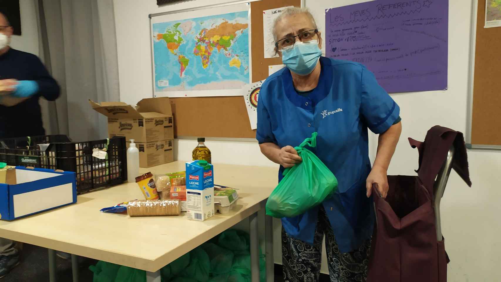 Una mujer recogiendo los alimentos que le dan en una ONG de Barcelona que colabora con el Banc dels Aliments / ELISABET GONZALEZ