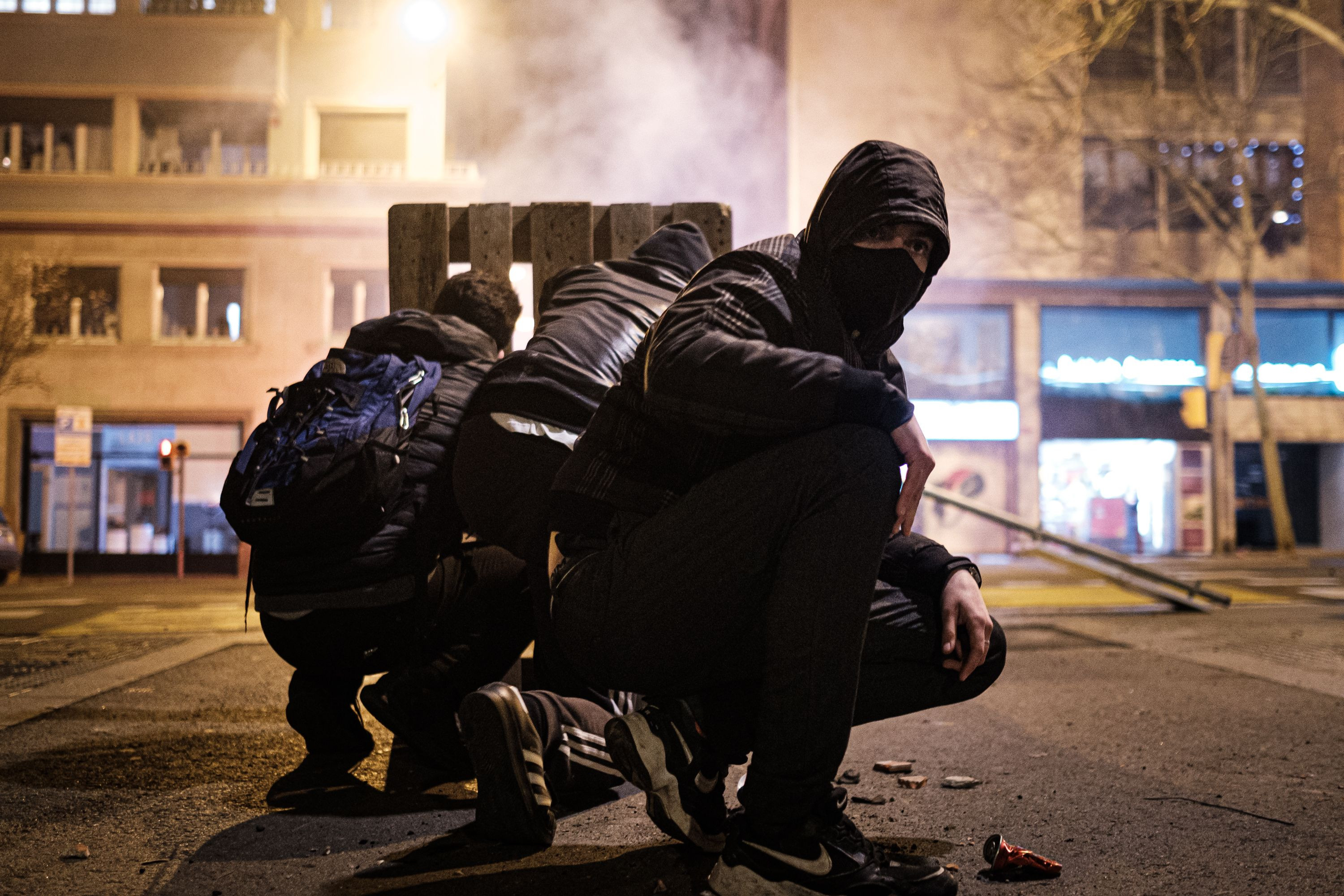 Jóvenes encapuchados se protegen de la policía el pasado martes en Barcelona / PABLO MIRANZO