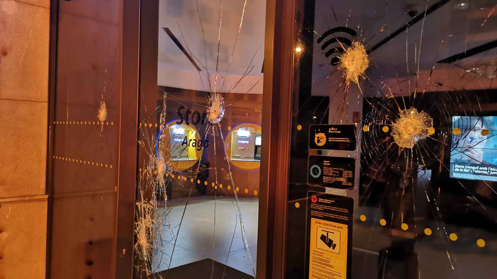 Entidad bancaria con cristales rotos en la calle de Aragó / GUILLEM ANDRÉS