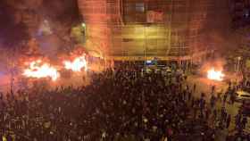 La proximidad del fuego de los disturbios a la malla del andamio pone en peligro a los habitantes de un edificio de la calle de Bailén / TWITTER - CEDIDA