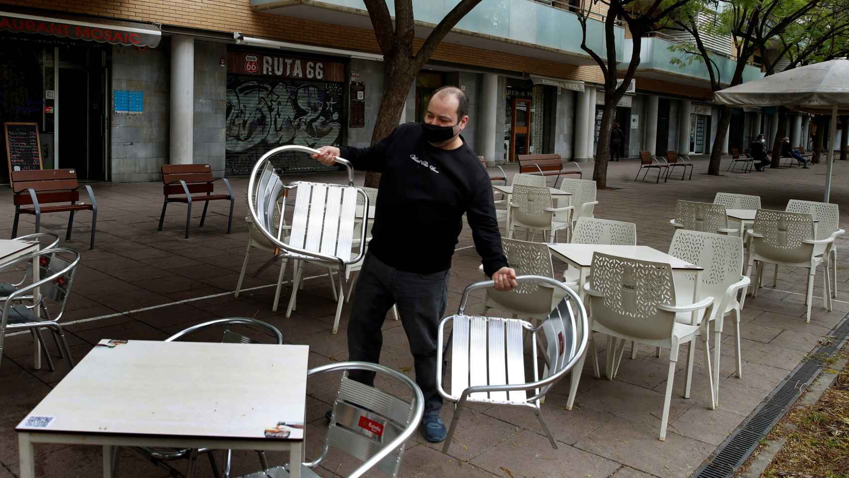 Un camarero prepara la terraza del restaurante donde trabaja para atender a sus clientes / EFE - Toni Albir